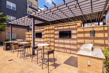 A patio with a table and chairs under a pergola.